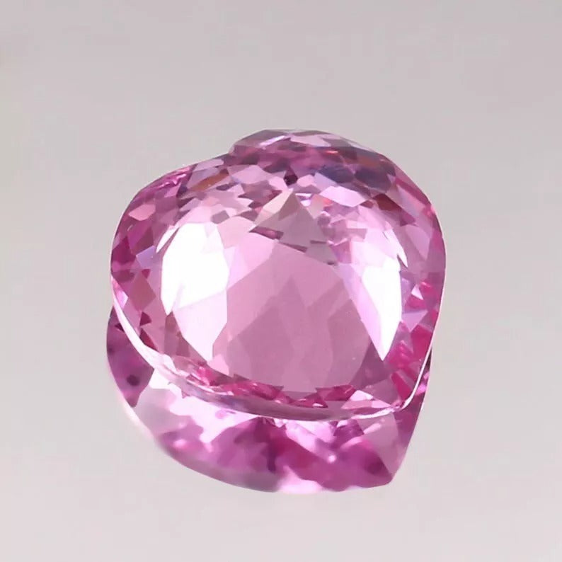 Heart-shaped Pink Morganite gemstone on a light gray background