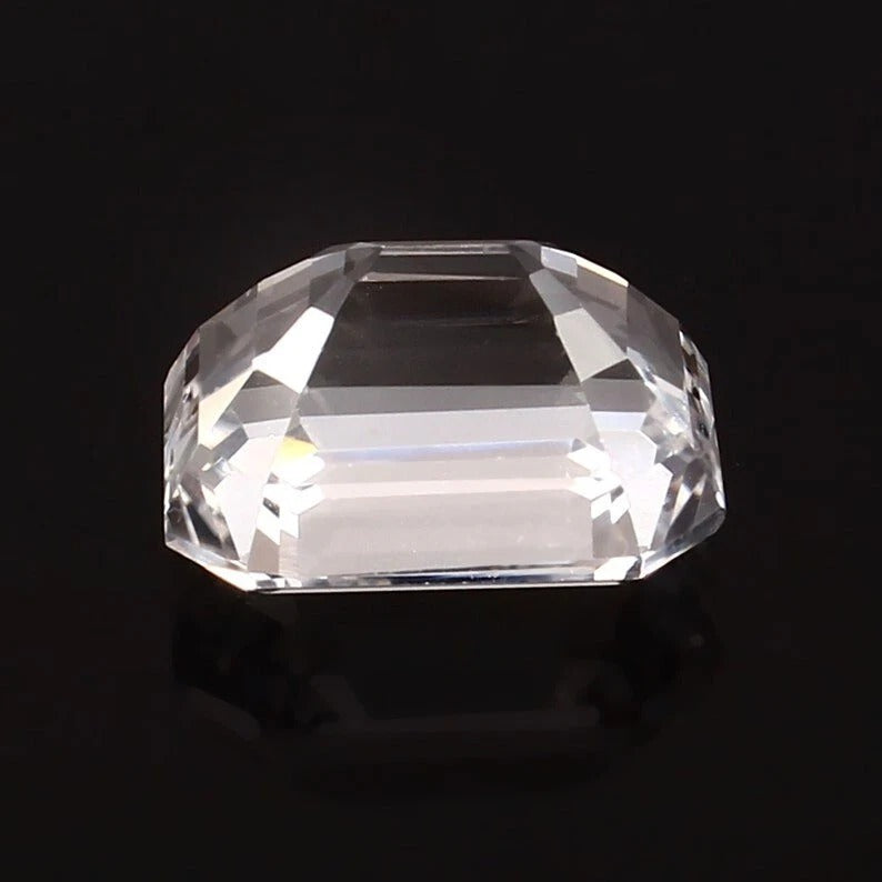 Clear emerald cut white sapphire on a black background