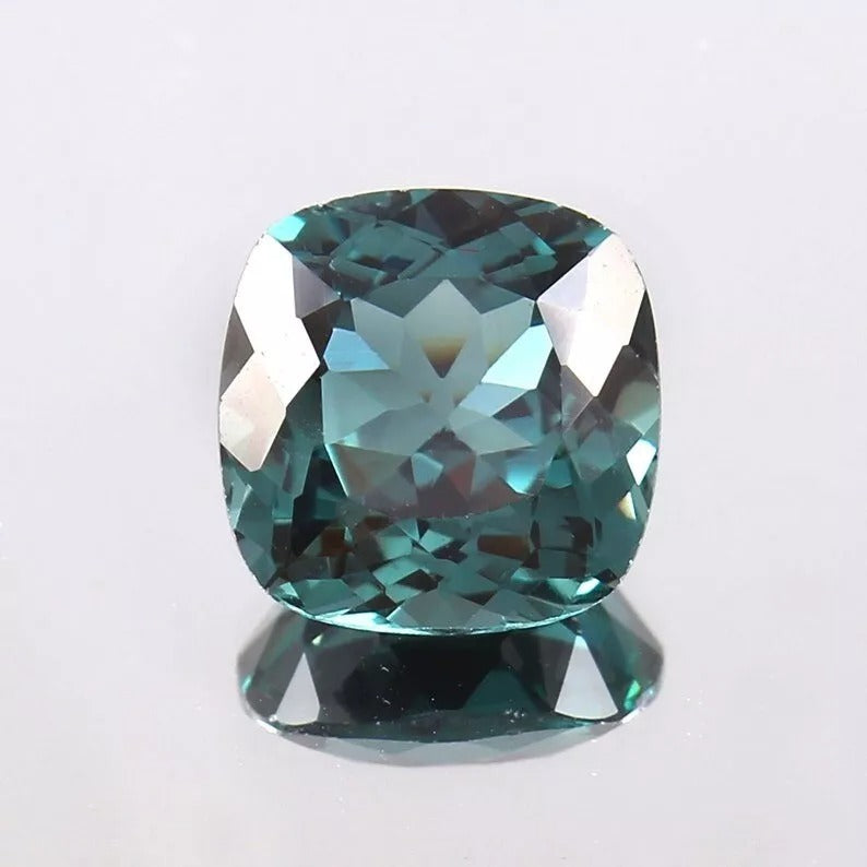 Teal Indicolite Tourmaline gemstone on a light gray background