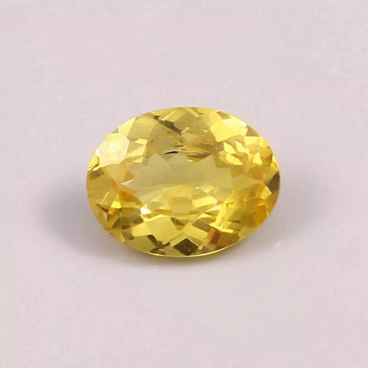 Yellow Sapphire gemstone on a light purple background
