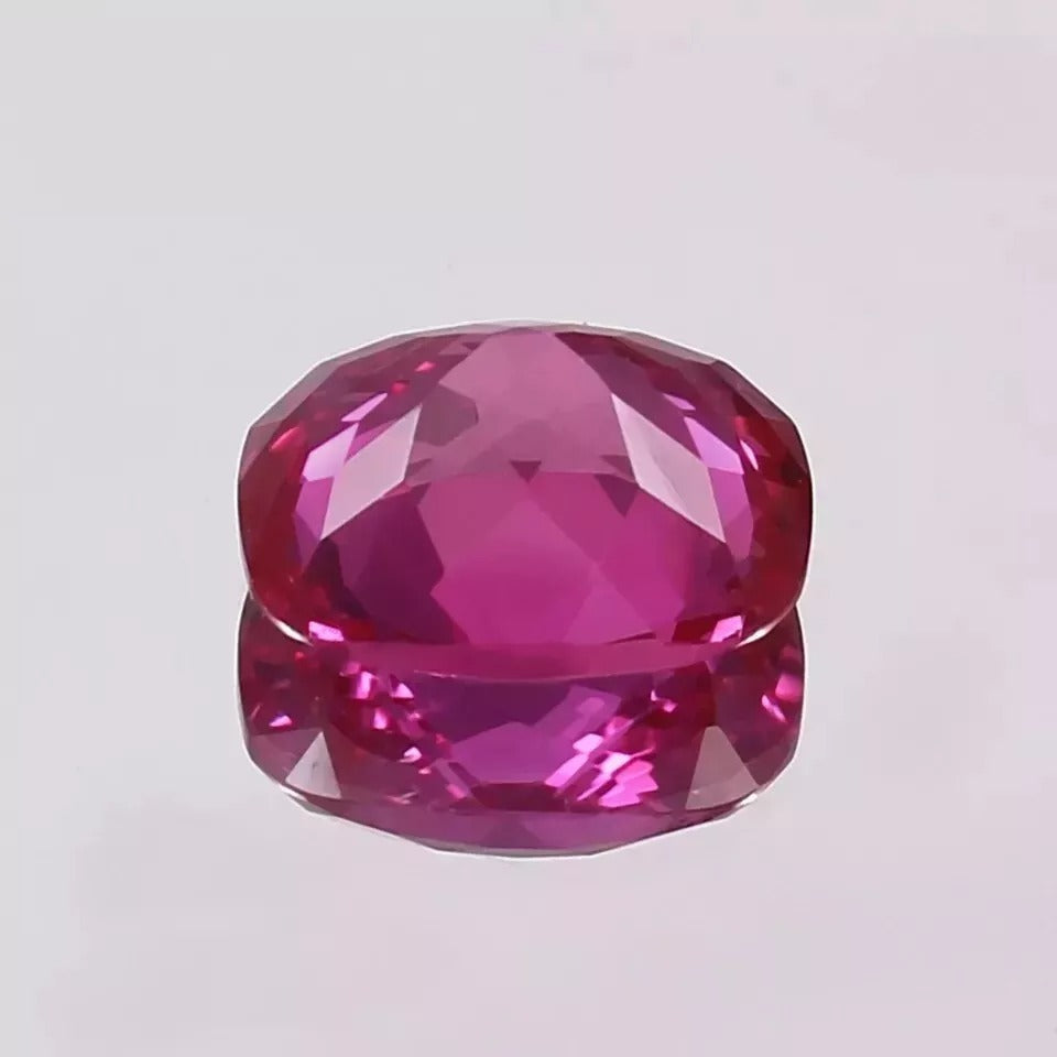 Faceted Pink sapphire gemstone on a light gray background