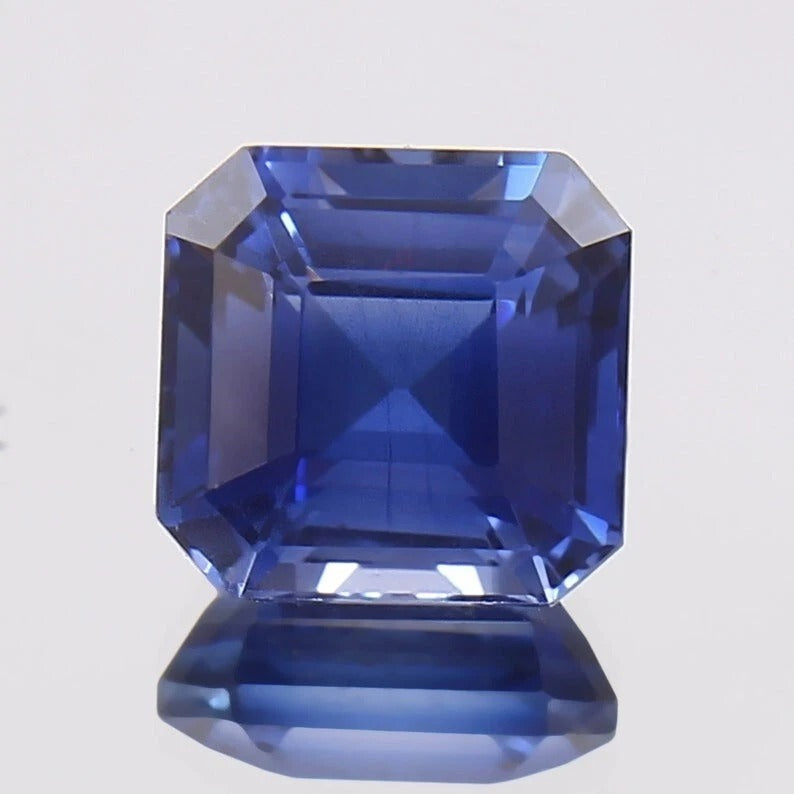 Faceted Royal Blue Sapphire on a light gray background