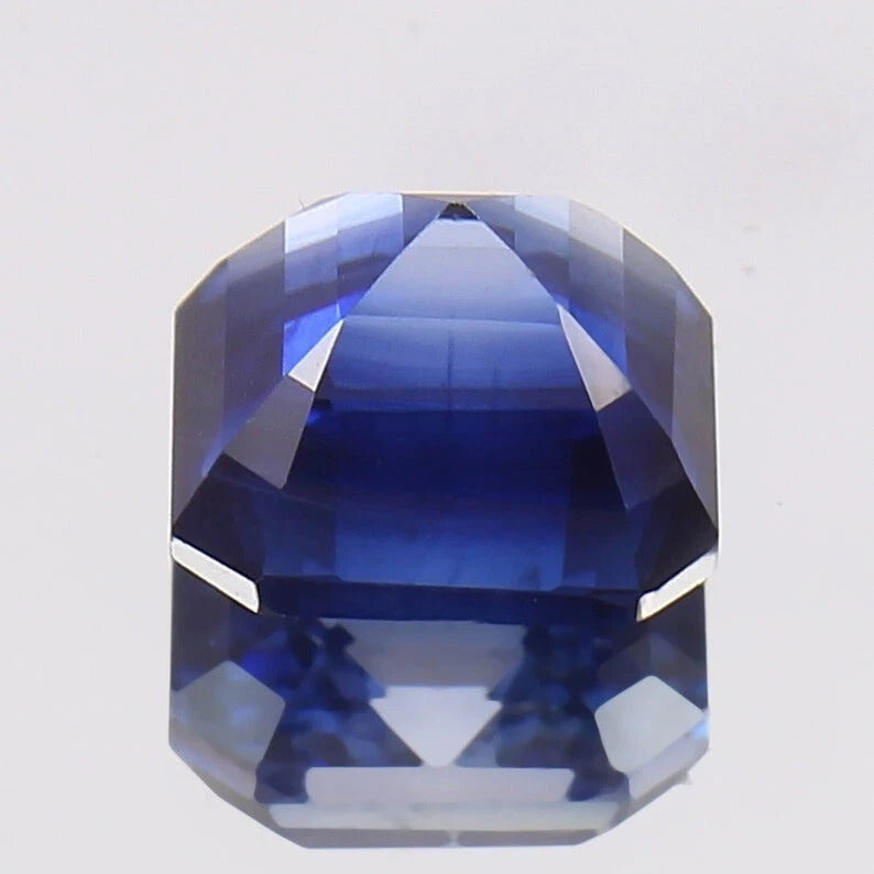 Faceted Royal Blue Sapphire on a light gray background