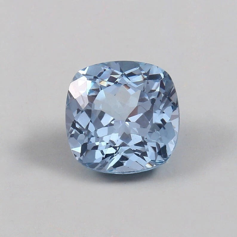 Cushion-shaped blue Aquamarine gemstone on a gray background