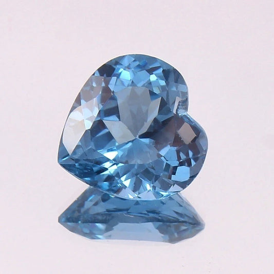 Heart-shaped Aquamarine blue gemstone on a light gray background