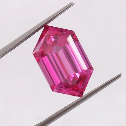 Ceylon Pink Sapphire gemstone held between tweezers on a light gray background