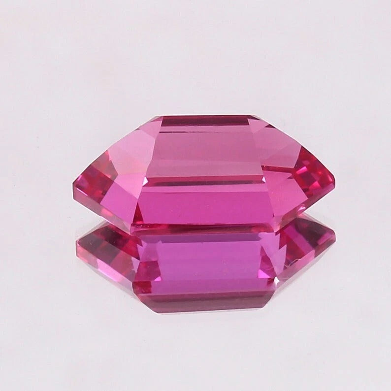 Faceted Ceylon Pink Sapphire gemstone on a light gray background