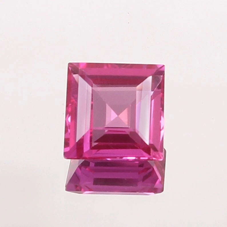 Pink Sapphire gemstone with a clear cut on a light pink background