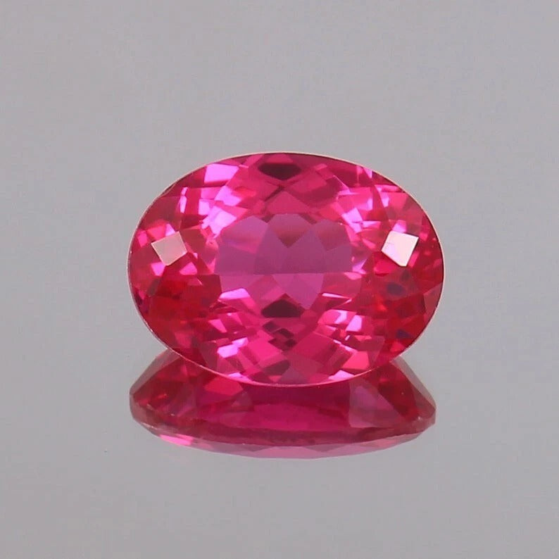 Faceted Ceylon Pink Sapphire gemstone on a gray background
