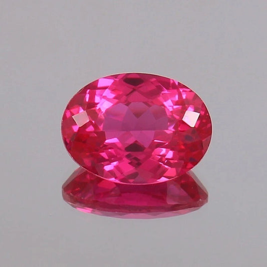 Faceted Ceylon Pink Sapphire gemstone on a gray background