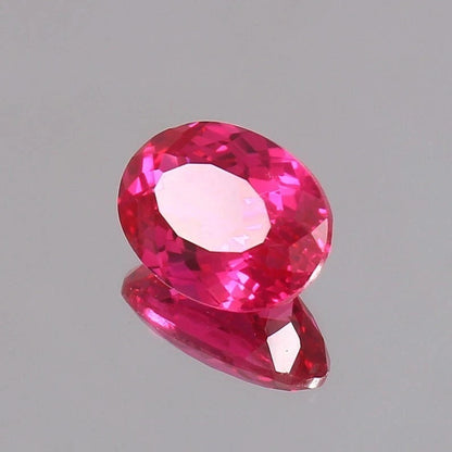 Faceted Ceylon Pink Sapphire gemstone on a gray background