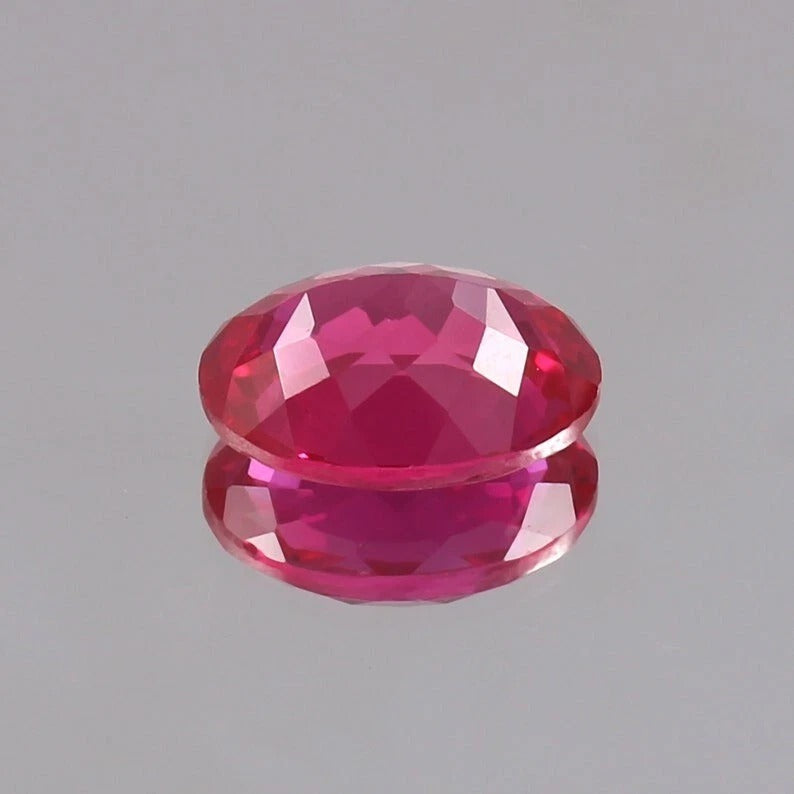 Faceted Ceylon Pink Sapphire gemstone on a gray background