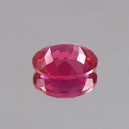 Faceted Ceylon Pink Sapphire gemstone on a gray background