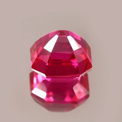 Faceted red gemstone on a beige background