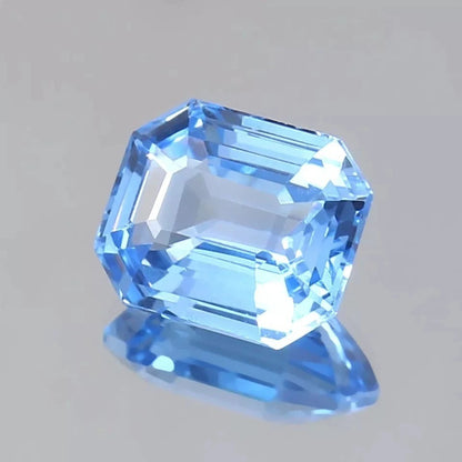 Blue Spinel gemstone with a hexagonal cut on a gray background