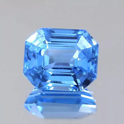 Faceted blue Spinel gemstone on a gray background