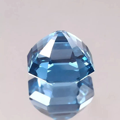 Faceted blue Aquamarine gemstone on a light gray background