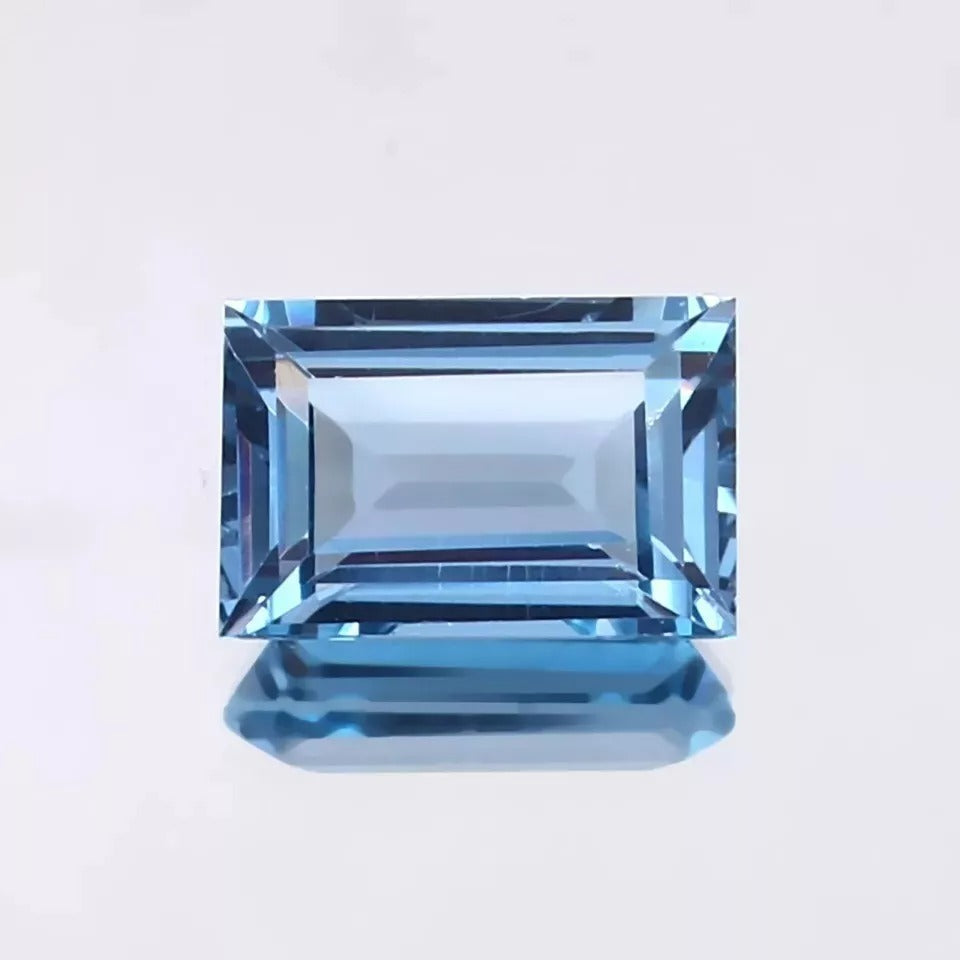 blue Aquamarine gemstone on a light gray background