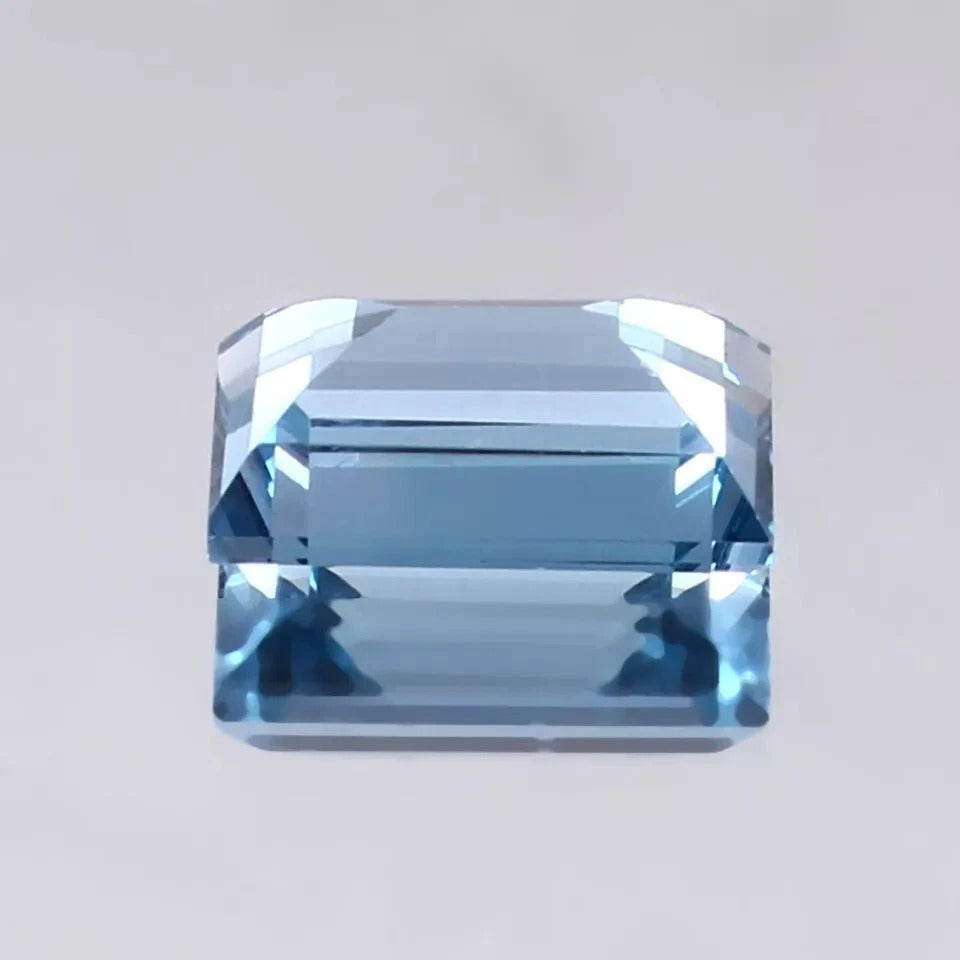 Aquamarine blue gemstone on a light gray background