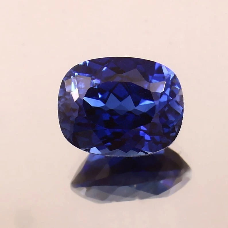 Faceted Royal Blue Sapphire gemstone on a beige background