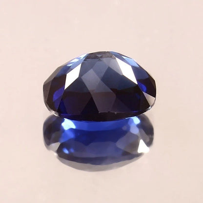 Faceted Royal Blue Sapphire gemstone on a beige background