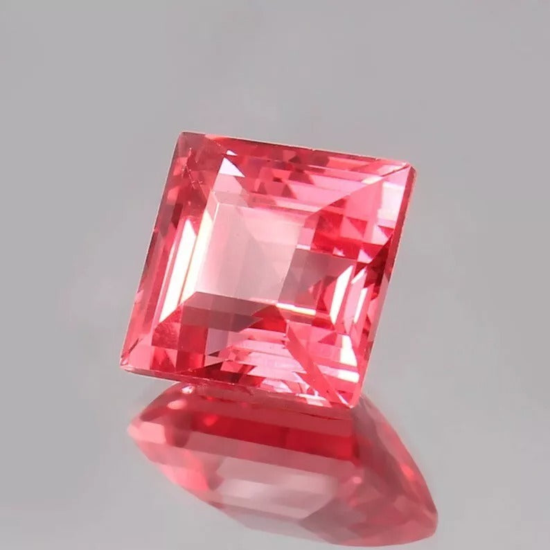 Square-cut Solomon Color Ceylon Padparadscha Sapphire gemstone on a gray background