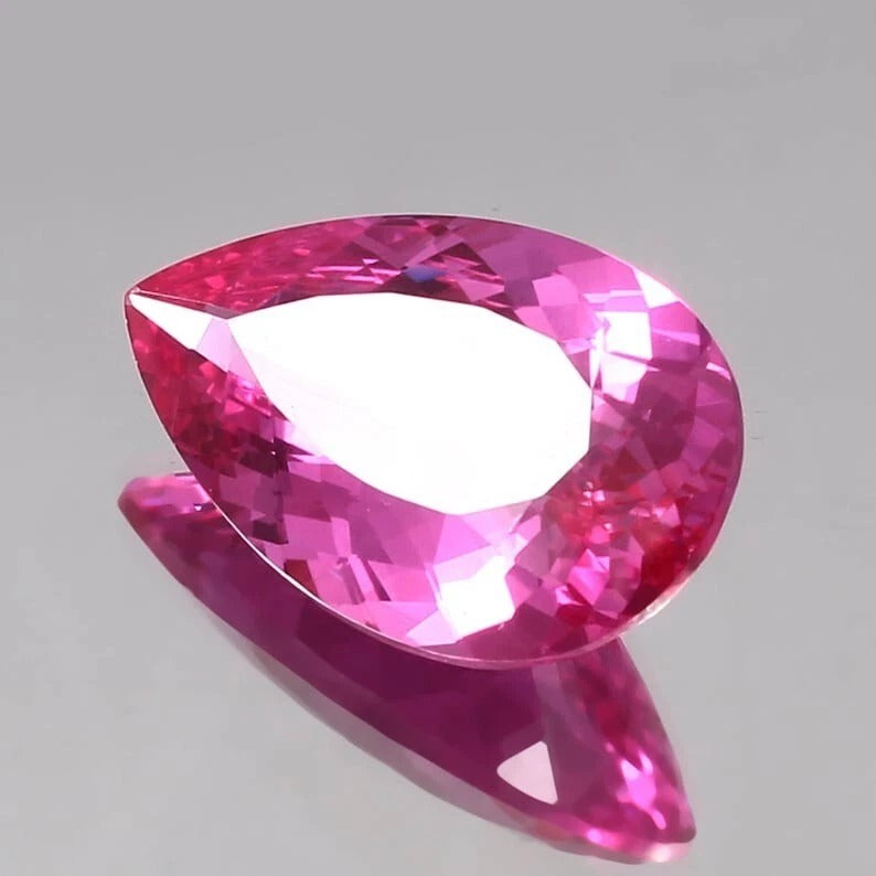 Faceted Flawless Ceylon Pink Sapphire gemstone on a gray background