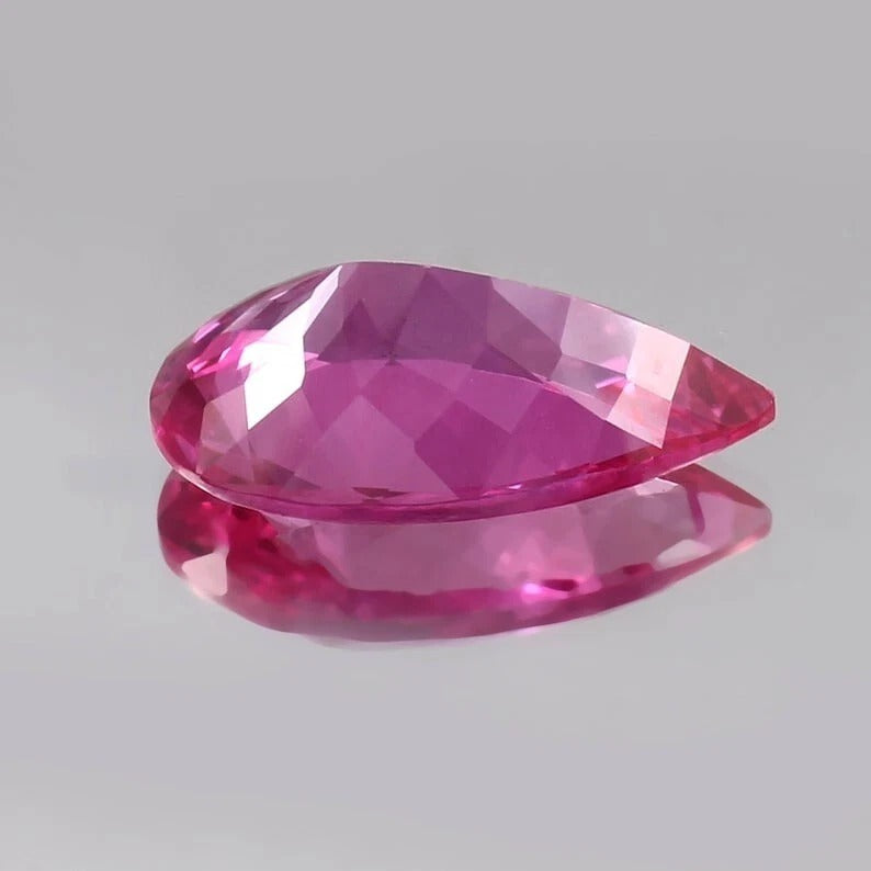 Faceted Flawless Ceylon Pink Sapphire gemstone on a gray background