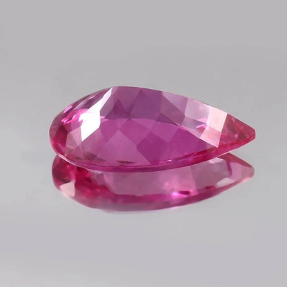 Faceted Flawless Ceylon Pink Sapphire gemstone on a gray background