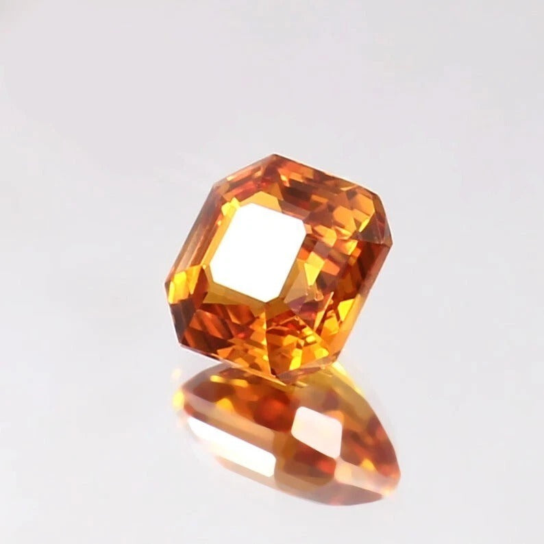 Faceted Ceylon Fanta Orange Sapphire Untreated gemstone on a light gray background