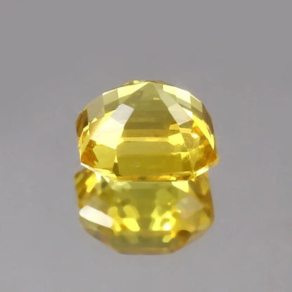 Faceted Yellow Sapphire Asscher gemstone on a gray background