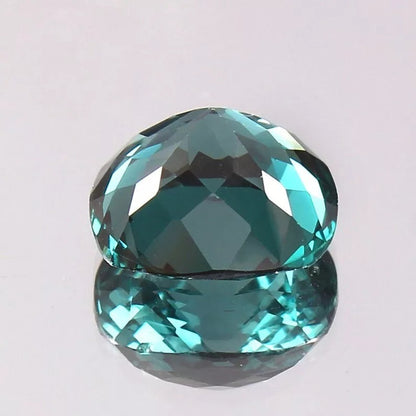 Faceted teal  Indicolite Tourmalinegemstone on a light gray background