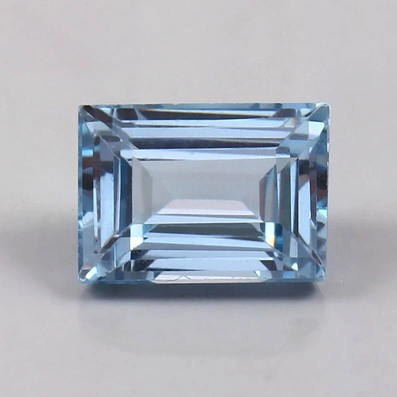 Brazilian Aquamarine Loose Baguette Cut gemstone on a light gray background