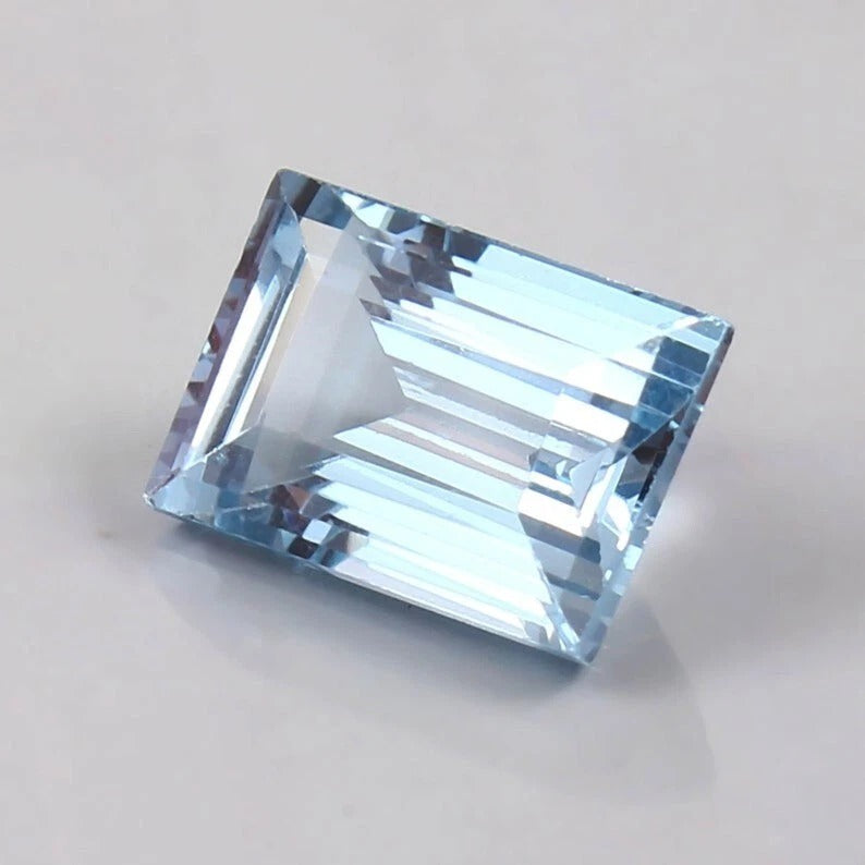 Brazilian Aquamarine Loose Baguette Cut blue gemstone on a light gray background