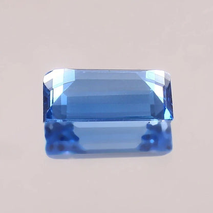 Brazilian Aquamarine Baguette Cut blue gemstone on a beige background