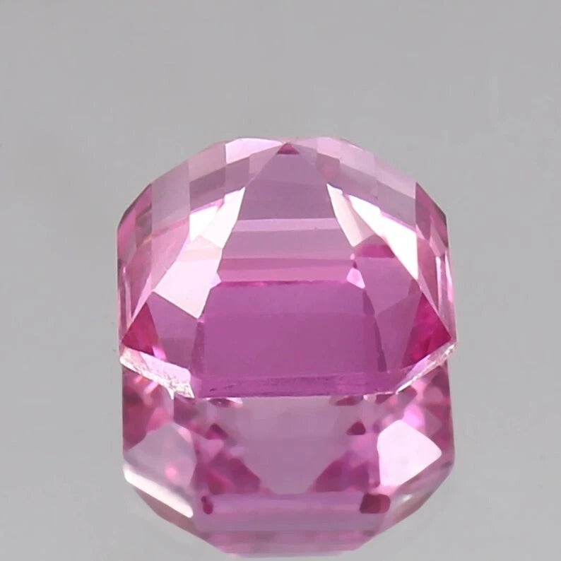 Faceted Pink Sapphire Unheated gemstone on a gray background