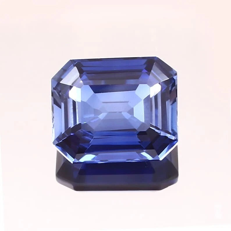 Blue Sapphire gemstone with a rectangular cut on a white background