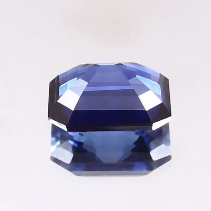 Faceted Blue Sapphire gemstone on a light gray background