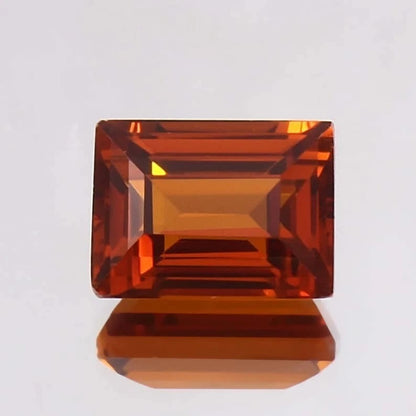 Baguette orange sapphire gemstone on a light gray background