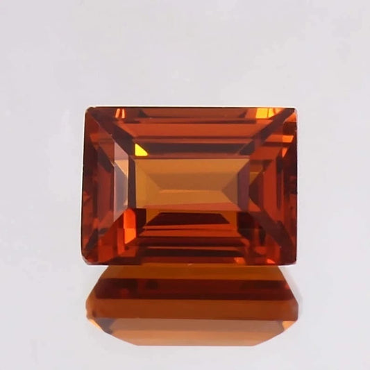 Baguette orange sapphire gemstone on a light gray background