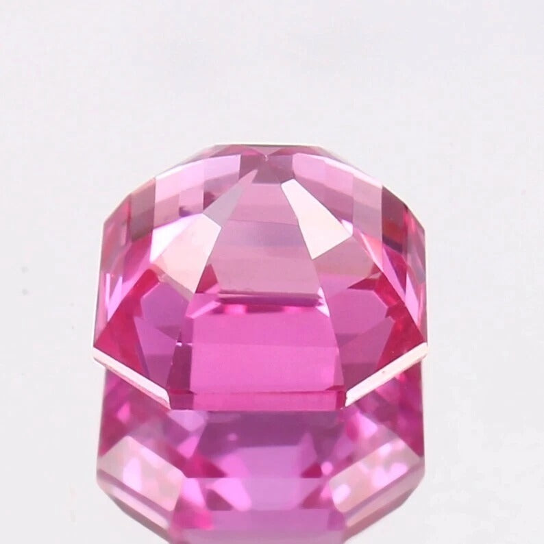 Faceted Pink Sapphire asscher gemstone on a light gray background