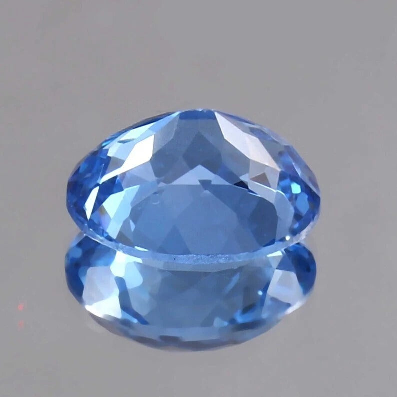 Faceted Blue Tourmaline Unheated gemstone on a gray background