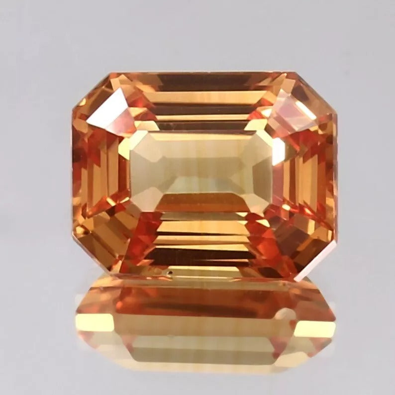 Octagonal Peach Padparadscha gemstone on a gray background