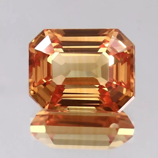 Octagonal Peach Padparadscha gemstone on a gray background