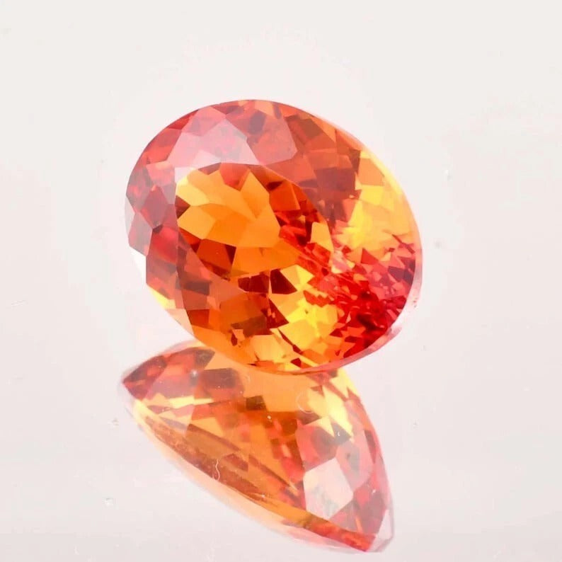 Fanta Orange Sapphire gemstone on a light gray background