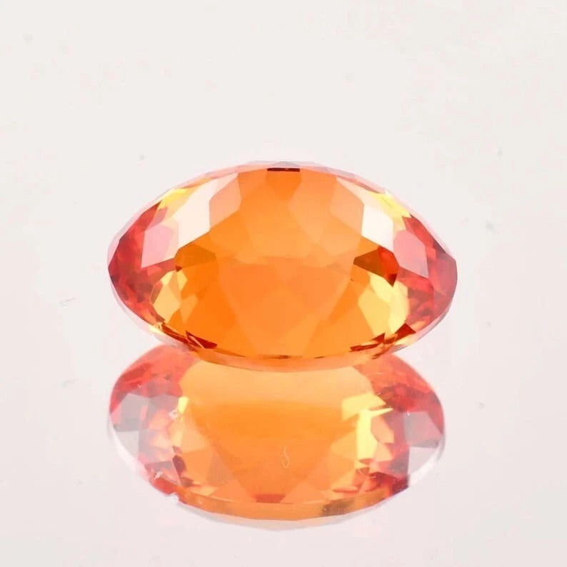 Fanta Orange Sapphire gemstone on a light gray background