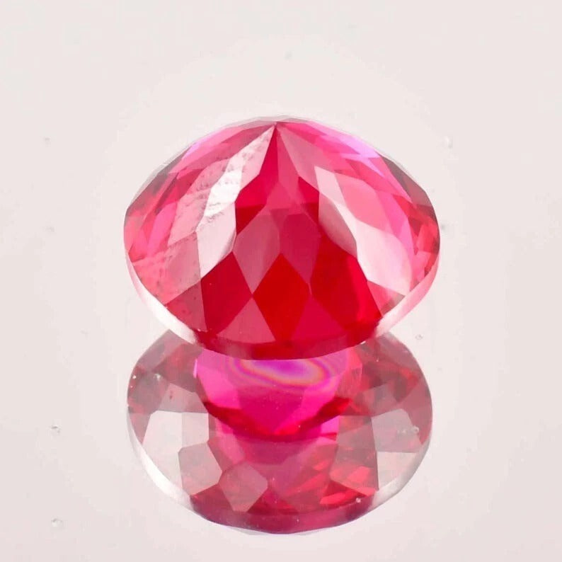 Faceted red ruby gemstone on a white background