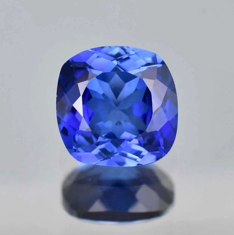 Blue Sapphire cushion -shaped blue gemstone on a gray background