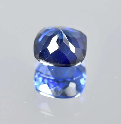 Blue Sapphire cushion gemstone on a light gray background