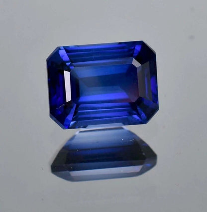 Faceted Royal Blue Sapphire gemstone on a light gray background